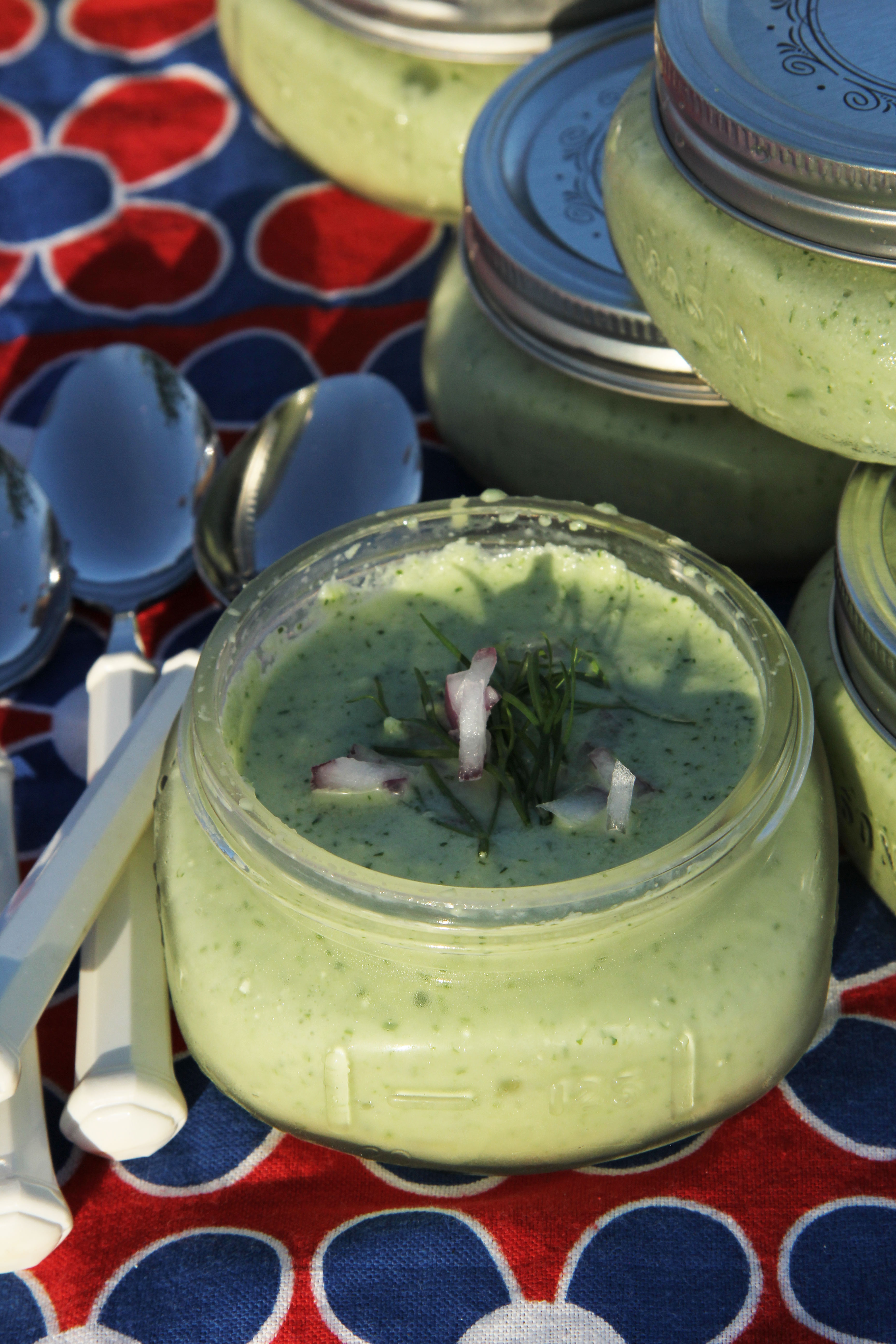 Serving Garnished Chilled Cucumber Dill and Yogurt Soup in Wide Mouth Mason Jars at a July Fourth Beach Picnic.