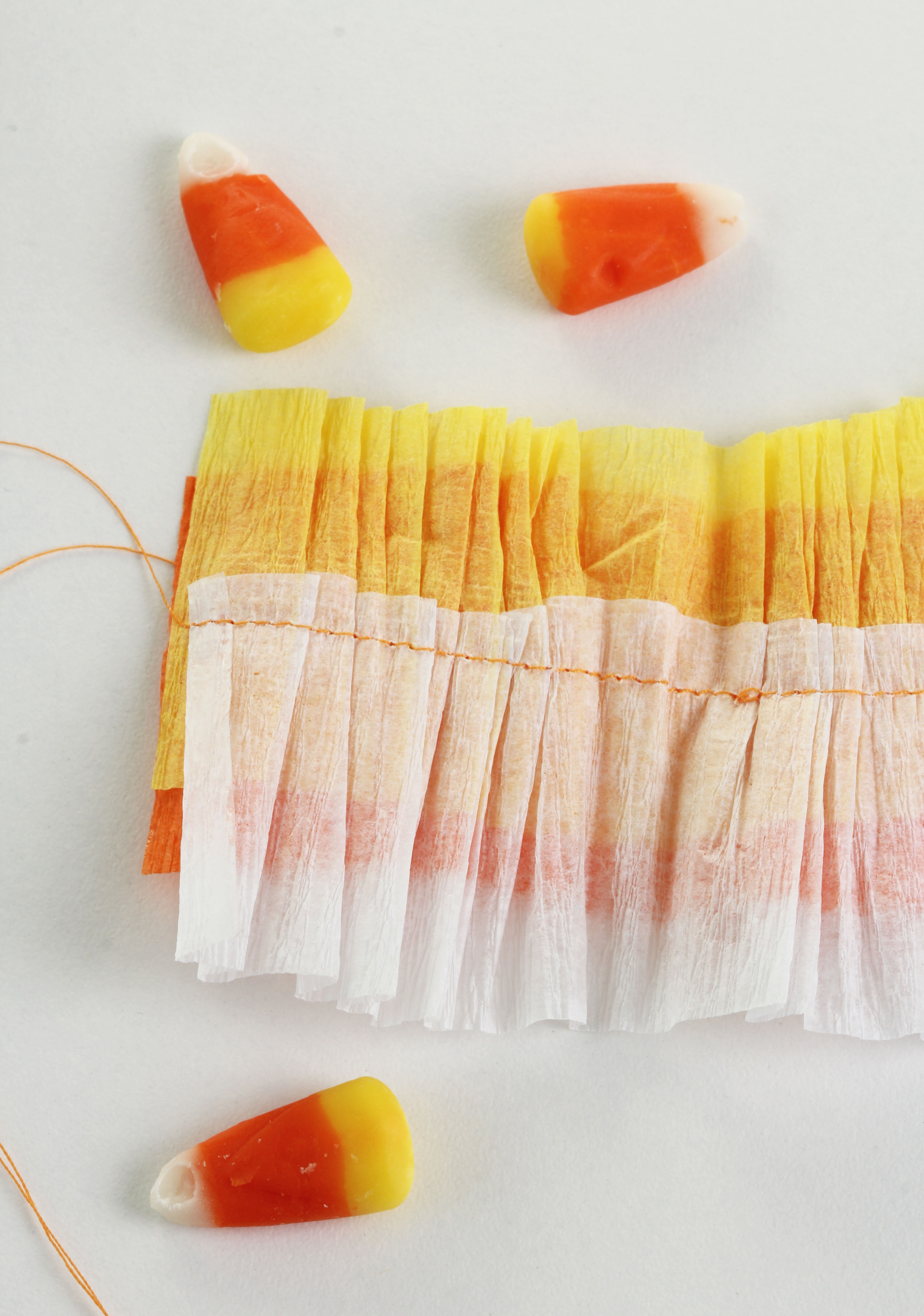 Make these festive DIY candy Corn Baskets by sewing 3 colors of crepe paper streamers together. it is fast and super easy!