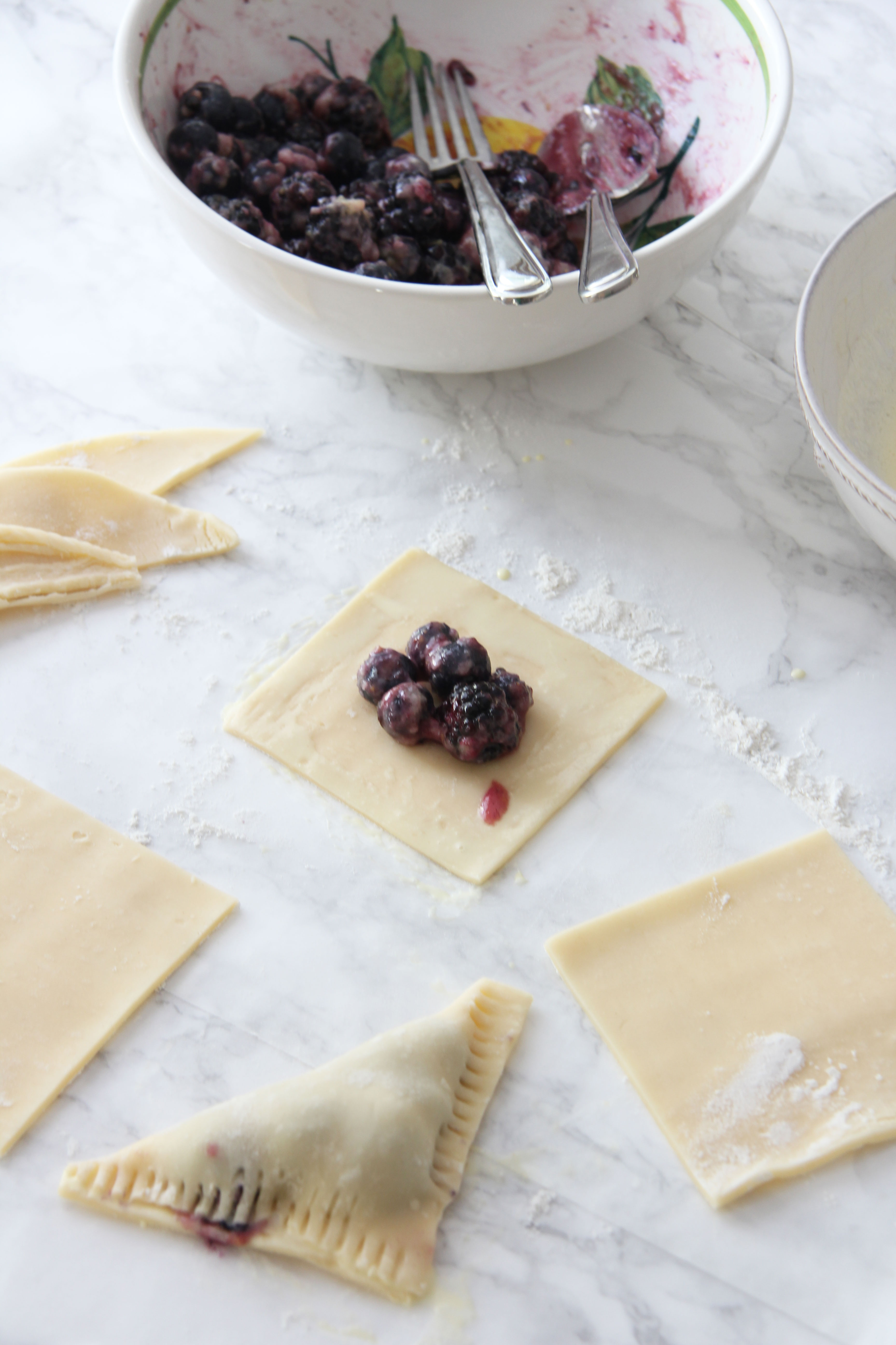 Assemble the blueberry blackberry turnovers with a spoonful of berry mixture in the middle of the pastry square. Fold over to make turnover.
